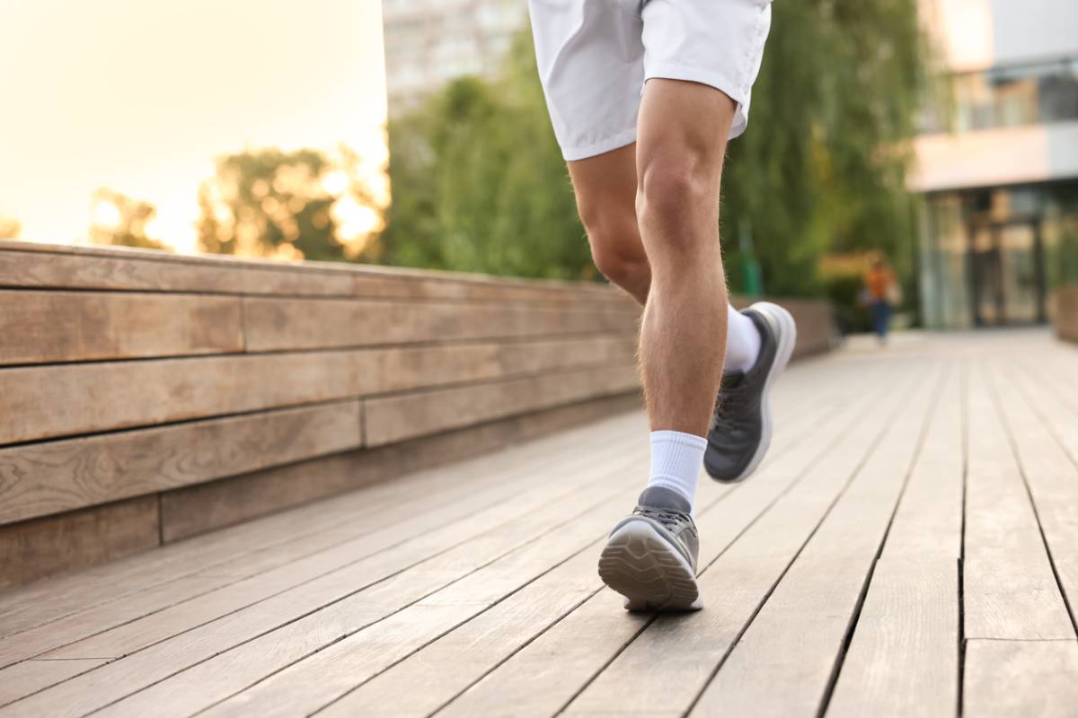 Closeup of man running in grey sneakers.